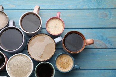 Photo of Many cups of different coffee drinks on light blue wooden table, flat lay