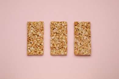 Tasty peanut bars (kozinaki) on pink background, flat lay