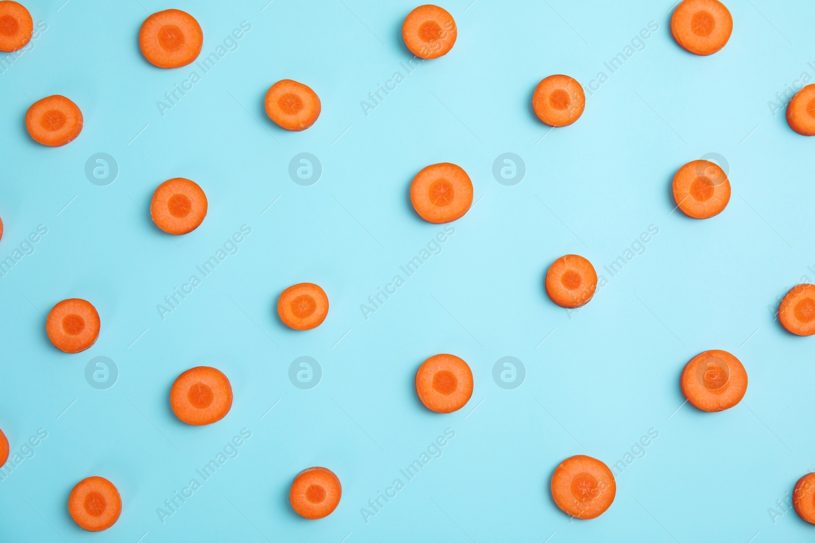 Photo of Flat lay composition with slices of carrots on color background