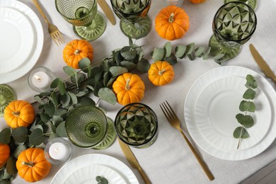 Beautiful autumn table setting. Plates, cutlery, glasses, pumpkins and floral decor, flat lay