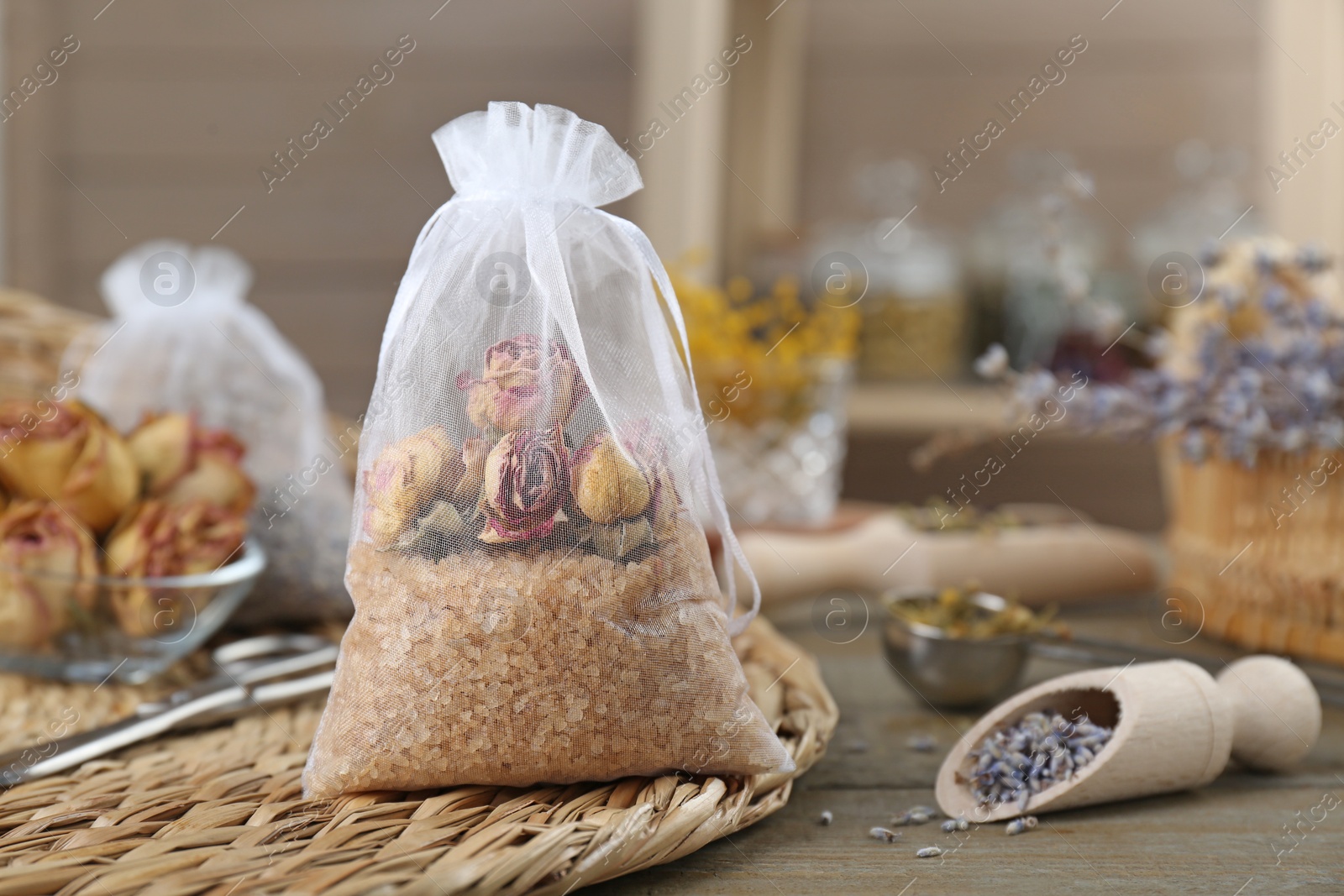 Photo of Scented sachet with dried roses on table