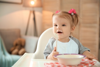Cute little girl eating healthy food at home