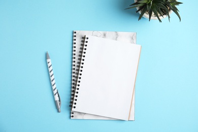 Photo of Flat lay composition with notebooks and pen on color background