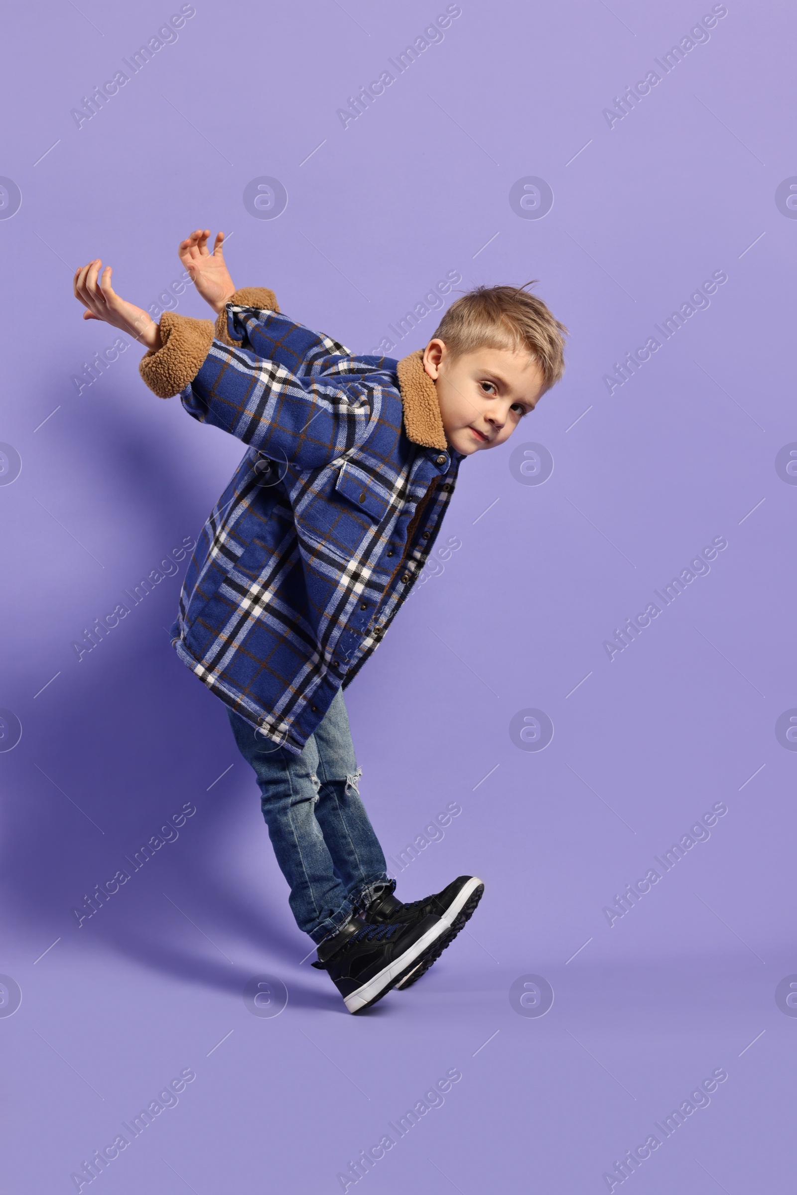 Photo of Fashion concept. Stylish boy posing on violet background