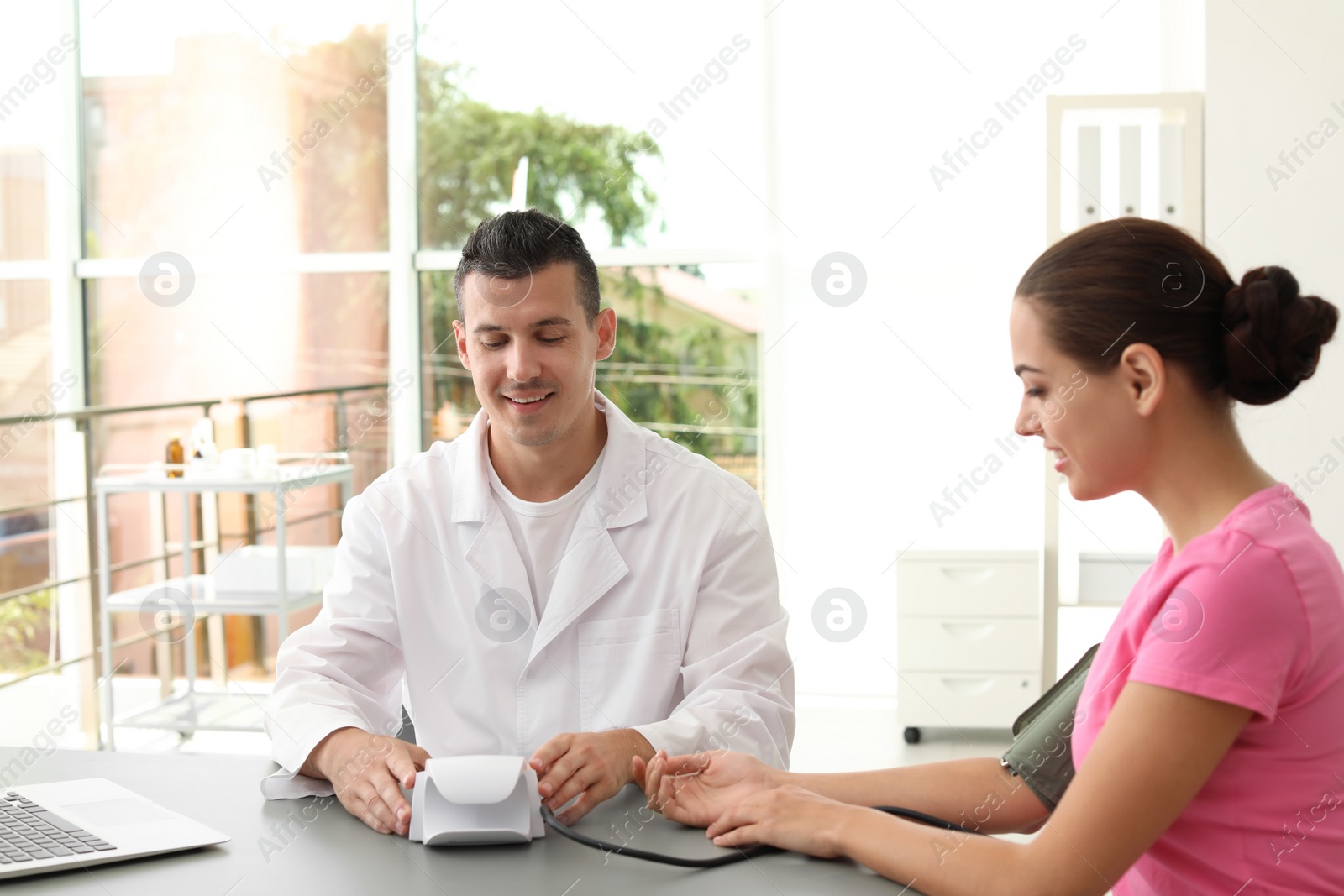 Photo of Doctor checking patient's blood pressure in hospital