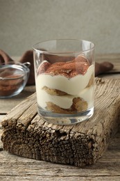 Delicious tiramisu in glass on wooden table