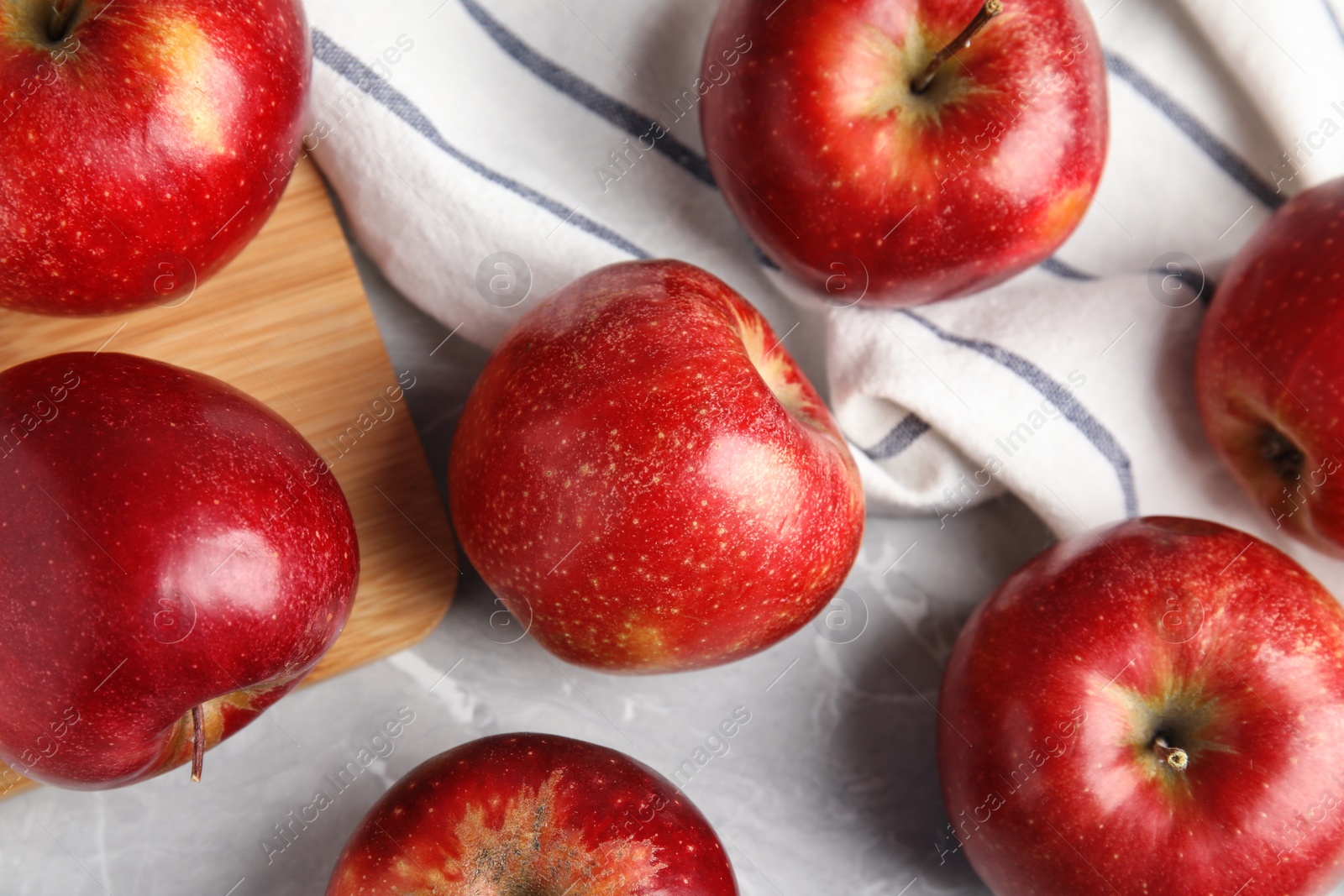 Photo of Ripe juicy red apples on grey background, flat lay