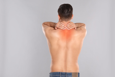 Image of Man suffering from pain in neck on light grey background