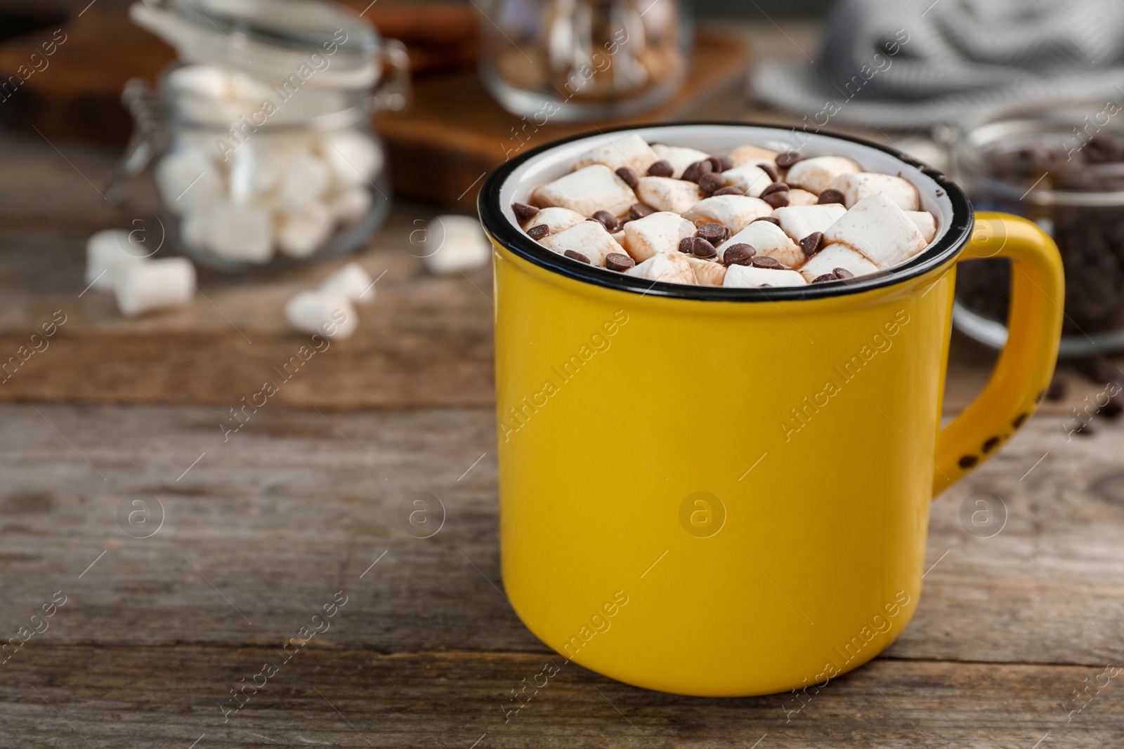 Photo of Cup of chocolate milk with marshmallows on wooden table, closeup