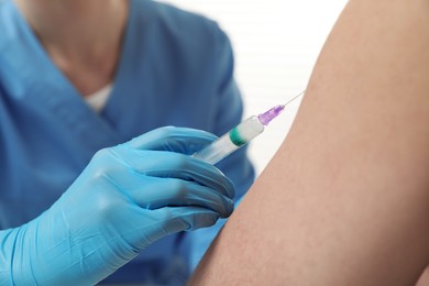 Doctor giving hepatitis vaccine to patient on white background, closeup