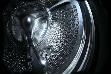 Photo of Empty washing machine drum, closeup. Laundry day