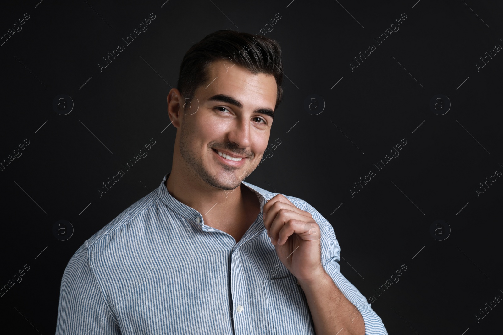 Photo of Portrait of handsome young man on black background