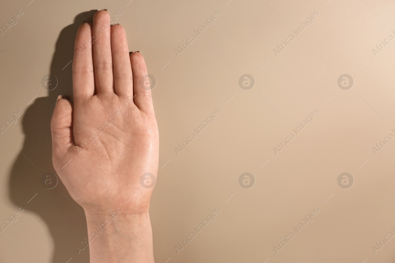 Photo of Woman showing palm on color background, top view with space for text. Chiromancy and foretelling