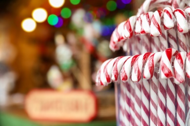 Photo of Candy canes on Christmas fair stall display, closeup. Space for text