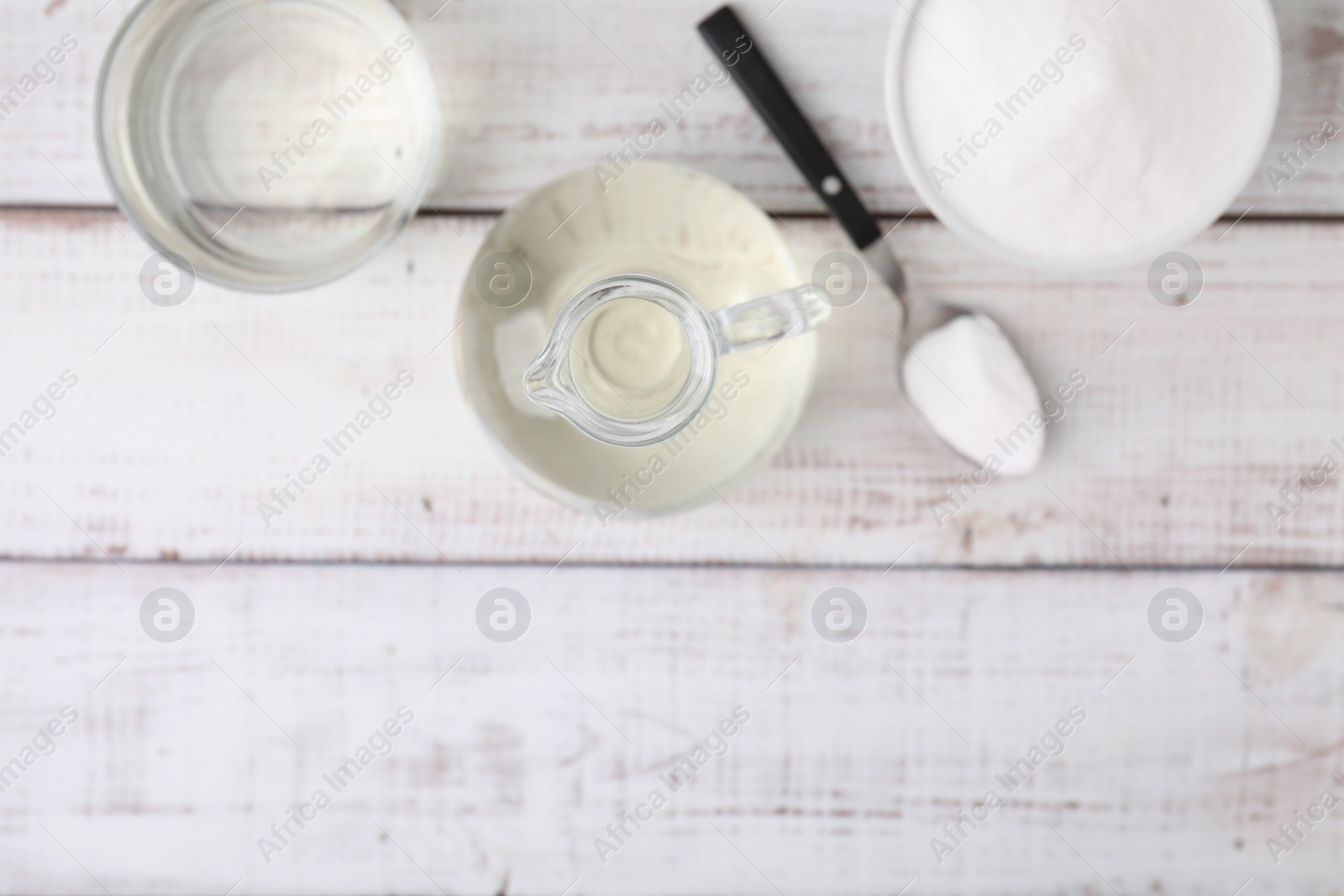 Photo of Vinegar and baking soda on white wooden table, flat lay. Space for text