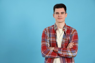 Portrait of handsome young man on light blue background, space for text