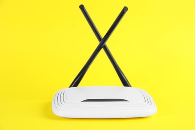 Photo of New modern Wi-Fi router on yellow background