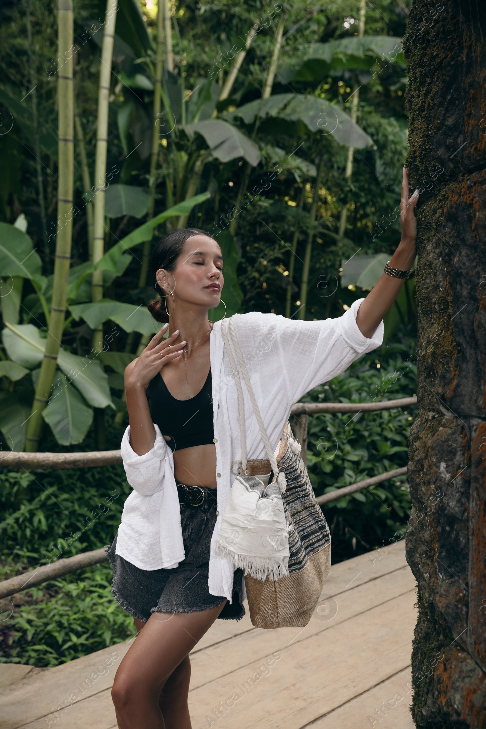 Photo of Beautiful young woman in green tropical park