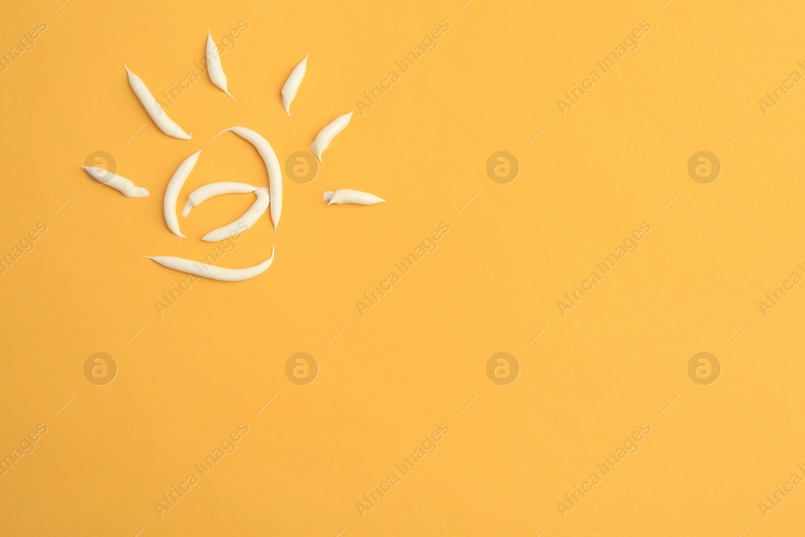 Photo of Drawing of sun with cream on orange background, top view and space for text. Skin care and protection