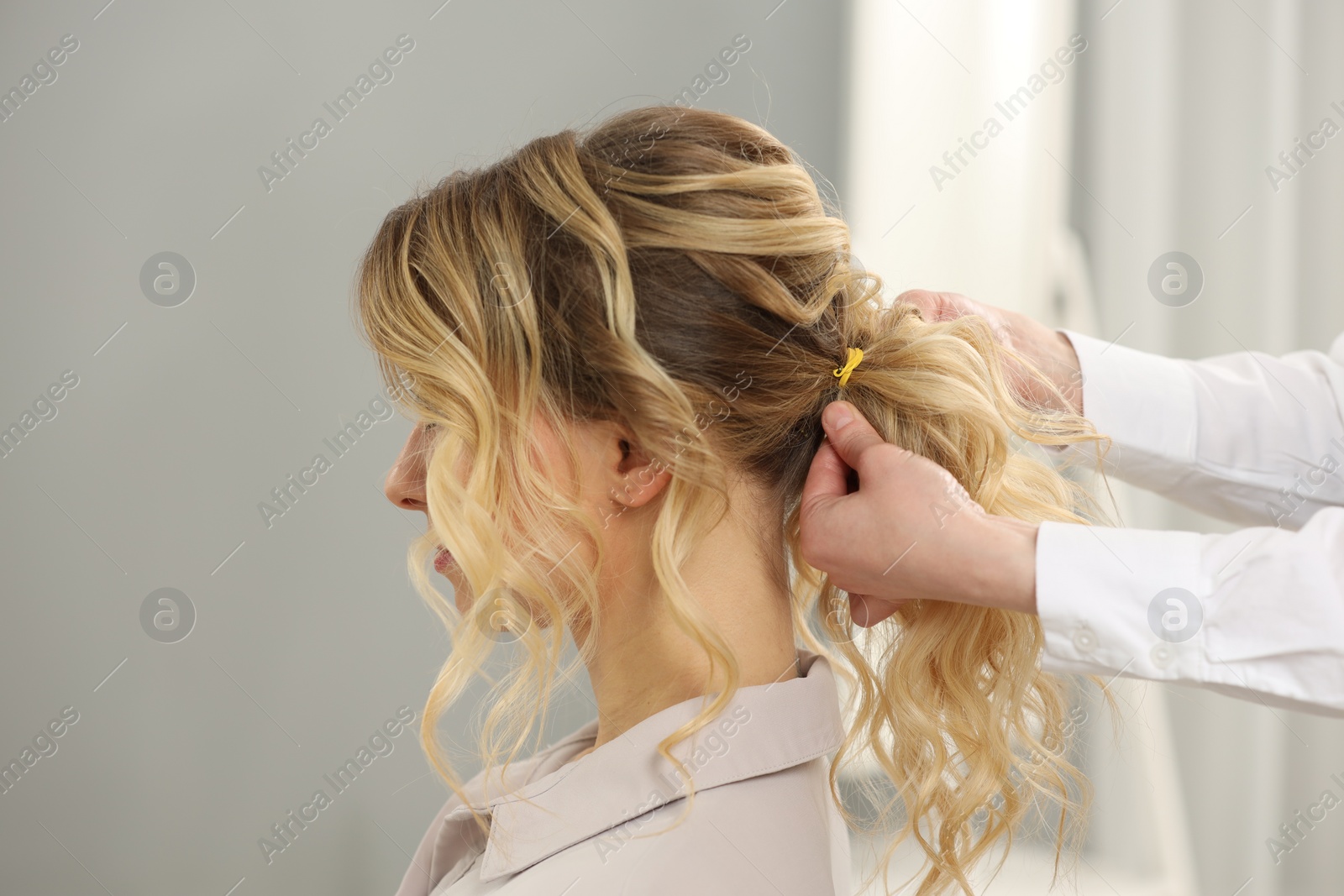 Photo of Hair styling. Professional hairdresser working with client indoors, closeup