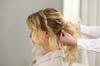 Photo of Hair styling. Professional hairdresser working with client indoors, closeup