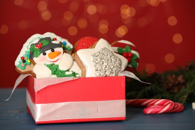 Photo of Sweet Christmas cookies on table against blurred festive lights
