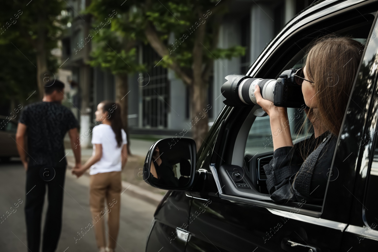 Photo of Private detective with camera spying from car