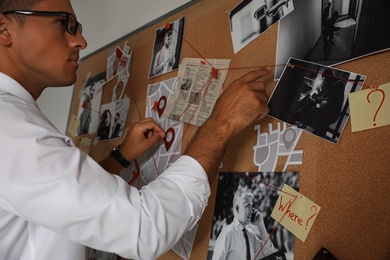 Detective looking at evidence board in office, closeup