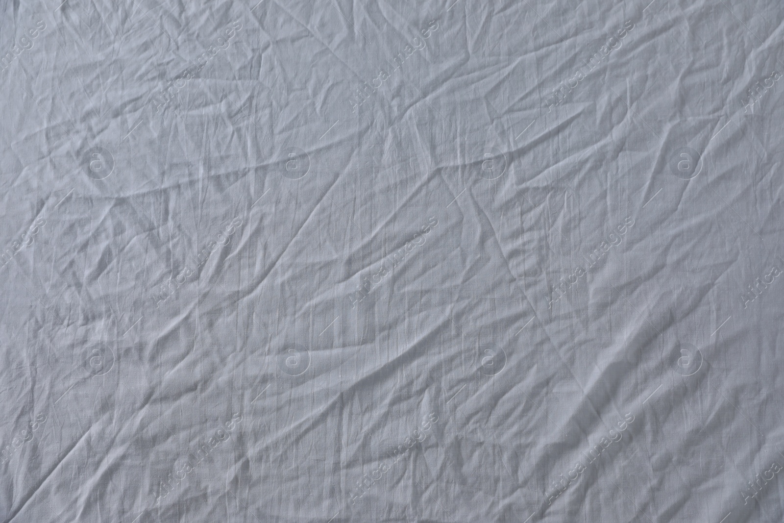 Photo of Crumpled white fabric as background, top view