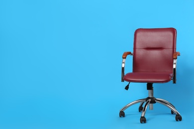 Photo of Comfortable office chair on light blue background, space for text