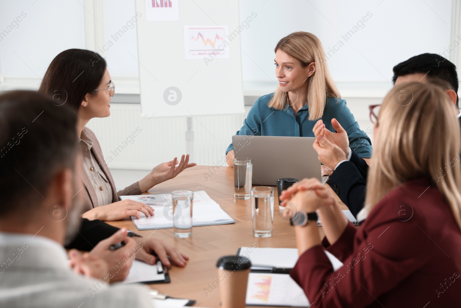 Photo of Businesswoman having meeting with her employees in office