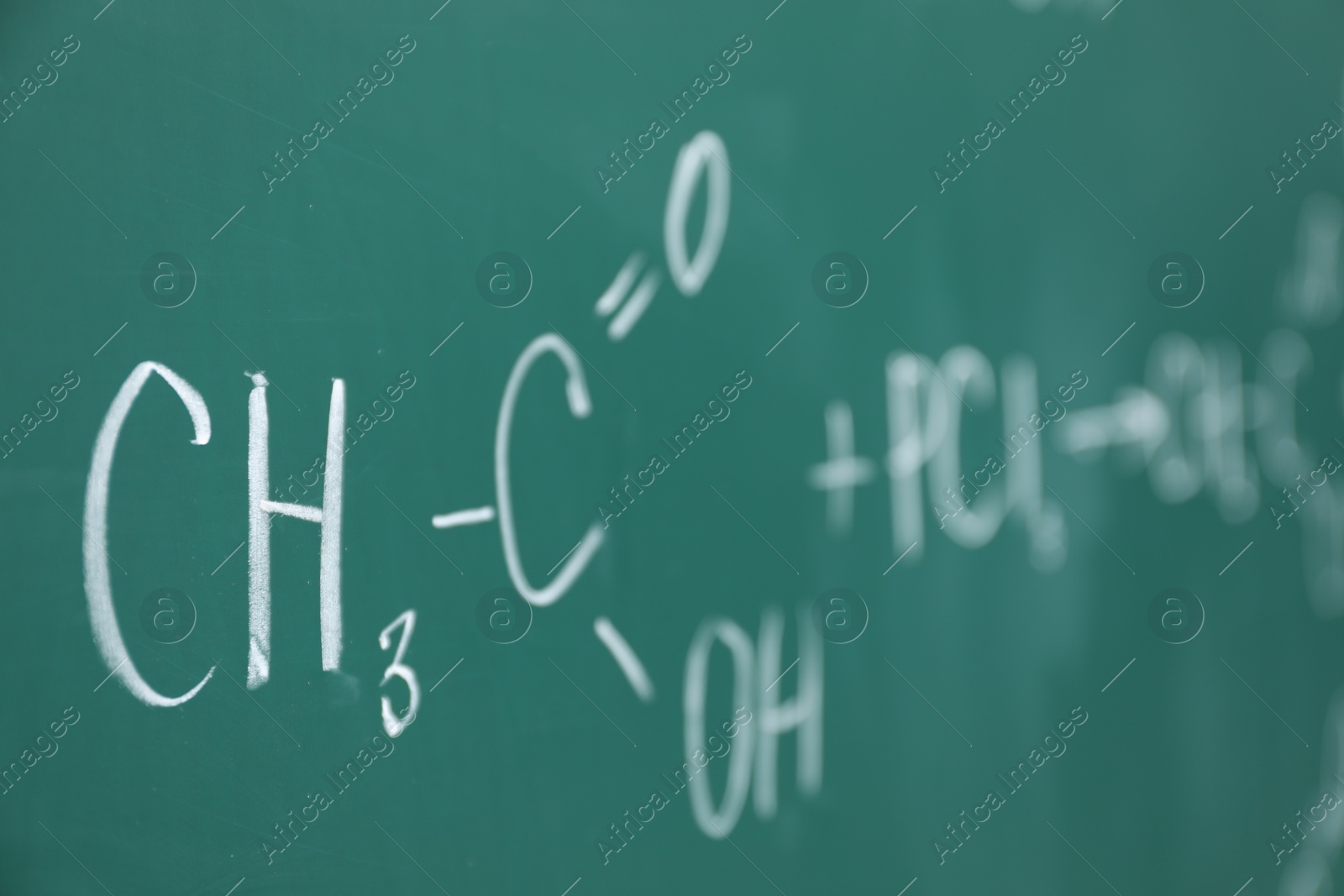 Photo of Chemical formulas written with chalk on green board, closeup