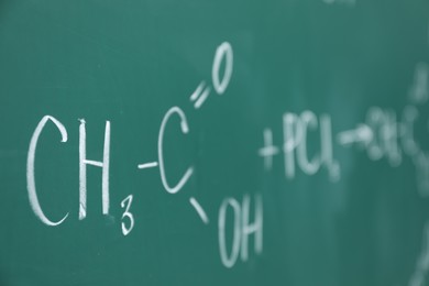 Photo of Chemical formulas written with chalk on green board, closeup