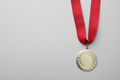 Photo of Gold medal with space for design on light background, top view. Victory concept