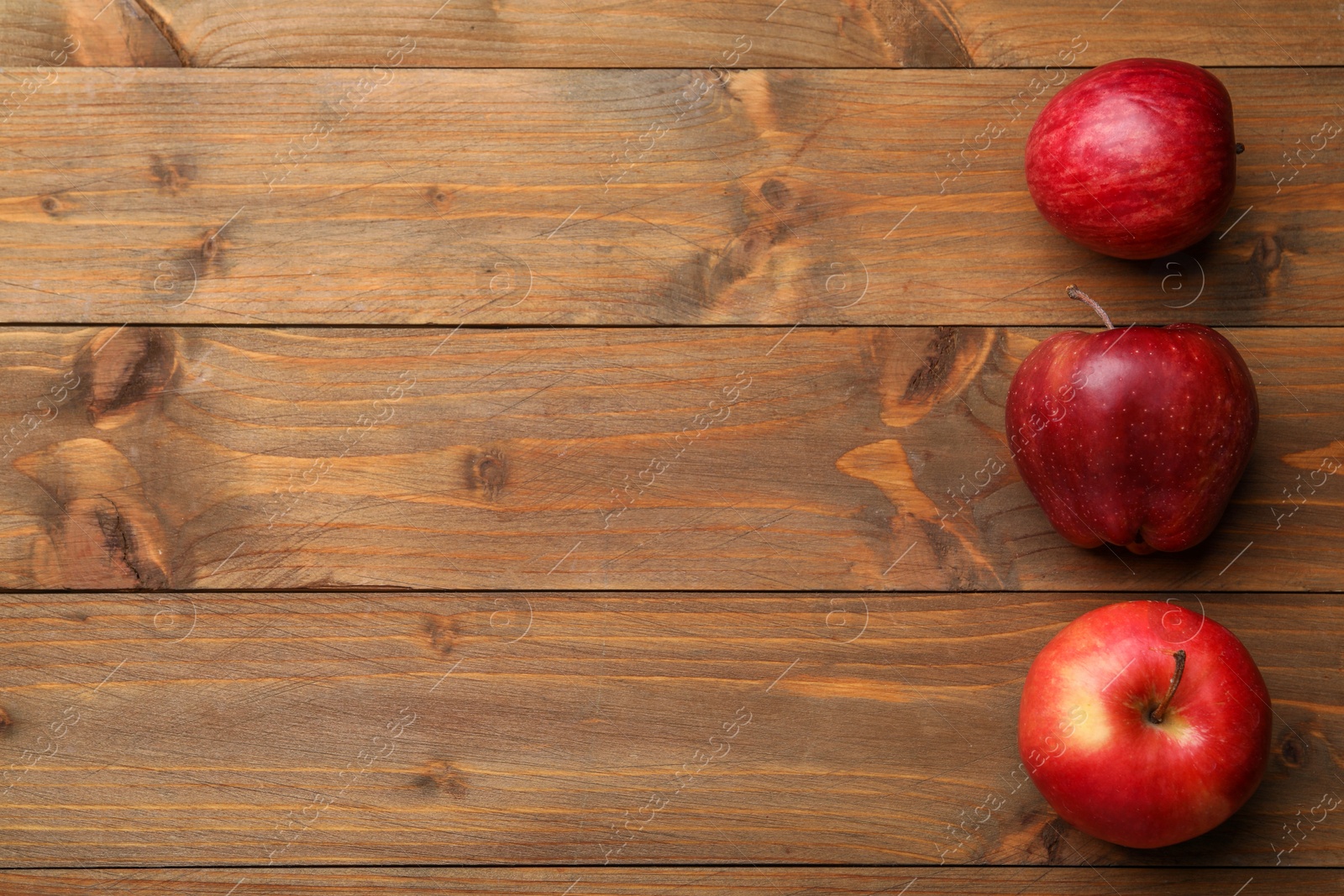 Photo of Fresh red apples on wooden table, flat lay. Space for text