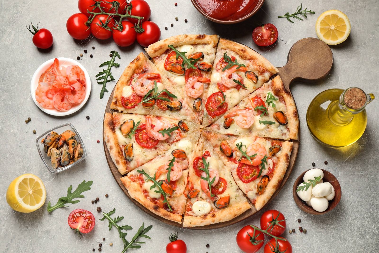 Photo of Delicious seafood pizza and fresh ingredients on light grey table, flat lay