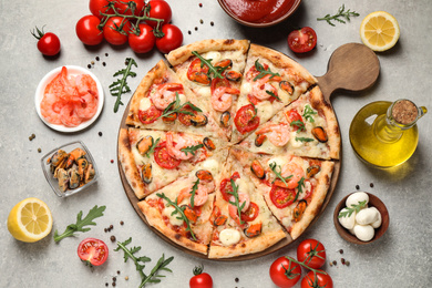 Photo of Delicious seafood pizza and fresh ingredients on light grey table, flat lay