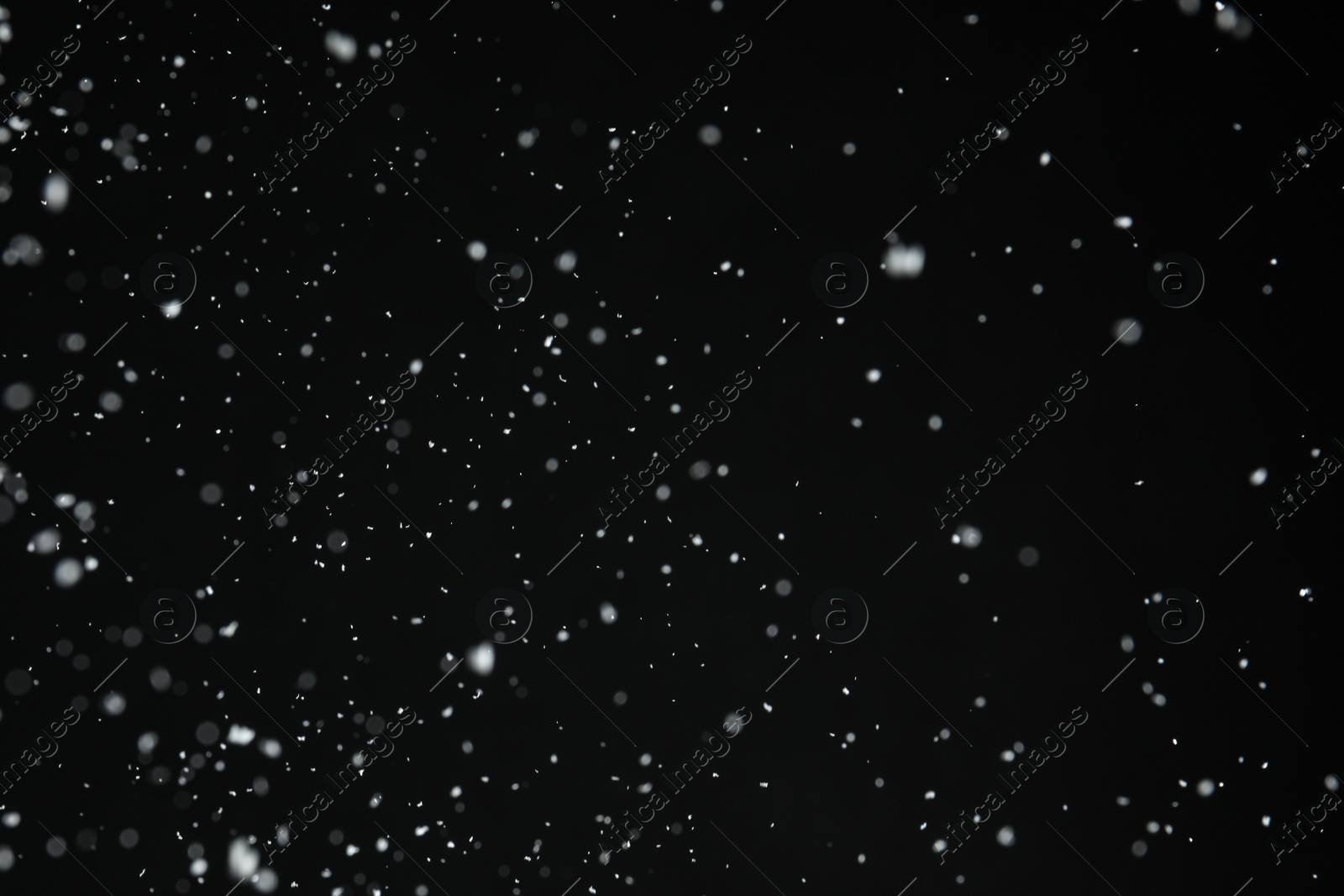 Photo of White snow falling down on black background