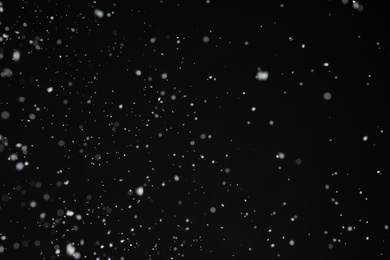 Photo of White snow falling down on black background