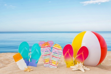 Photo of Sandy beach with different beach accessories near sea. Summer vacation