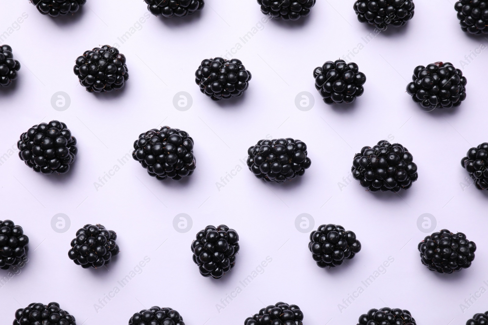 Photo of Tasty ripe blackberries on white background, flat lay