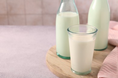 Photo of Glassware with tasty milk on table, closeup. Space for text