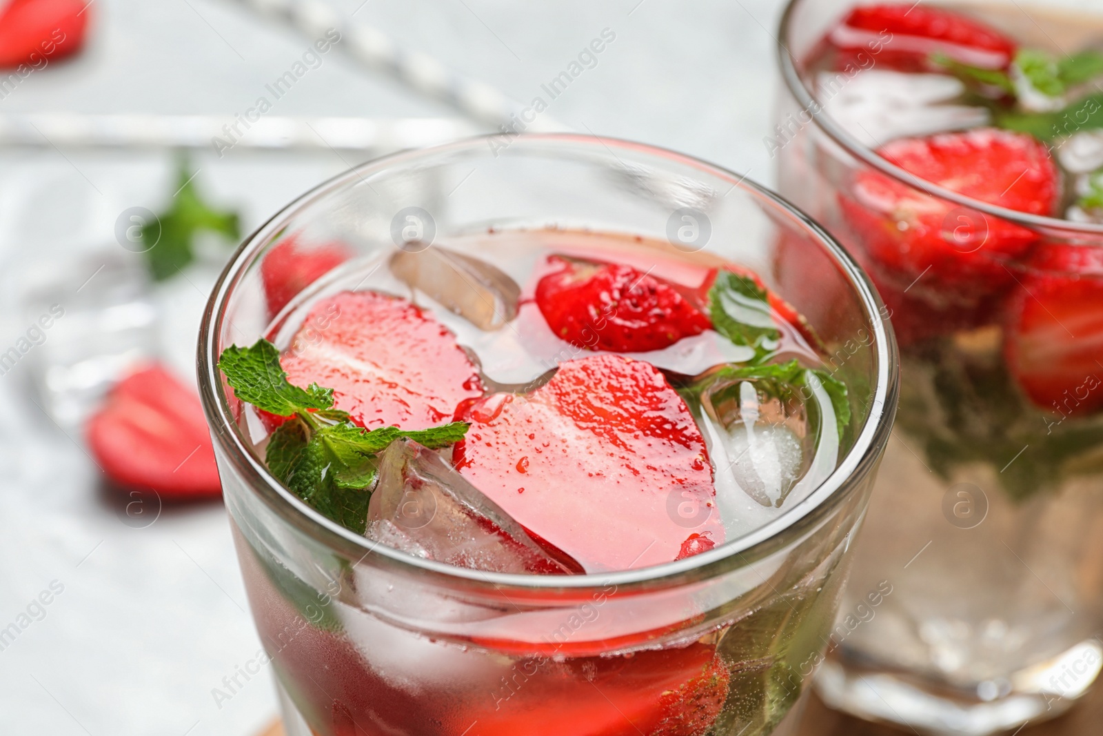 Photo of Glass of refreshing drink with strawberry and mint on table, closeup view