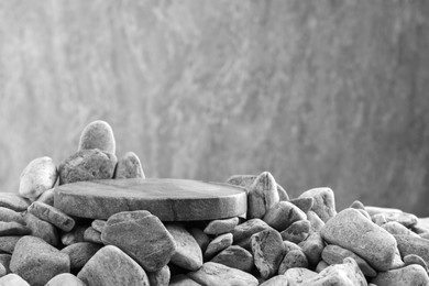 Photo of Presentation for product. Stone and pebbles on grey background. Space for text