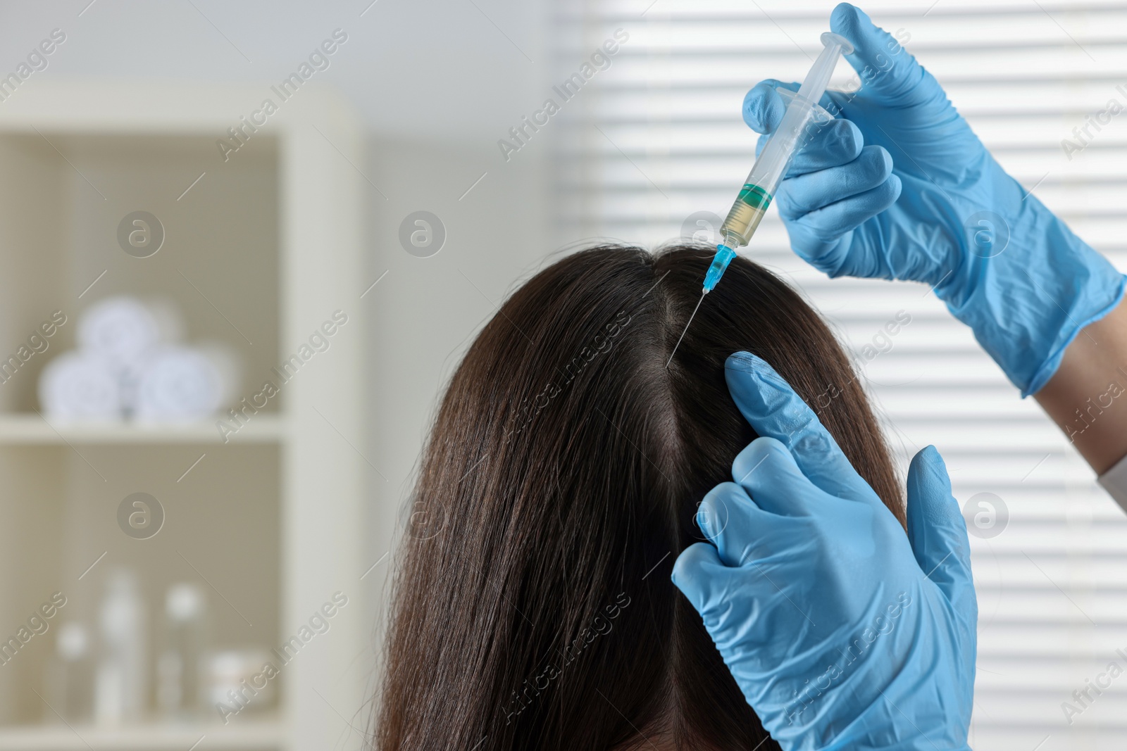 Photo of Trichologist giving injection to patient in clinic, closeup. Space for text