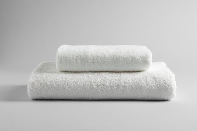 Photo of Fresh soft folded towels on light background