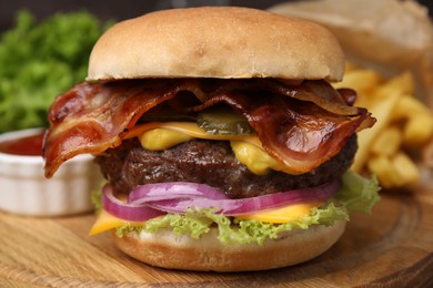 Photo of Tasty burger with bacon, vegetables and patty on wooden board, closeup