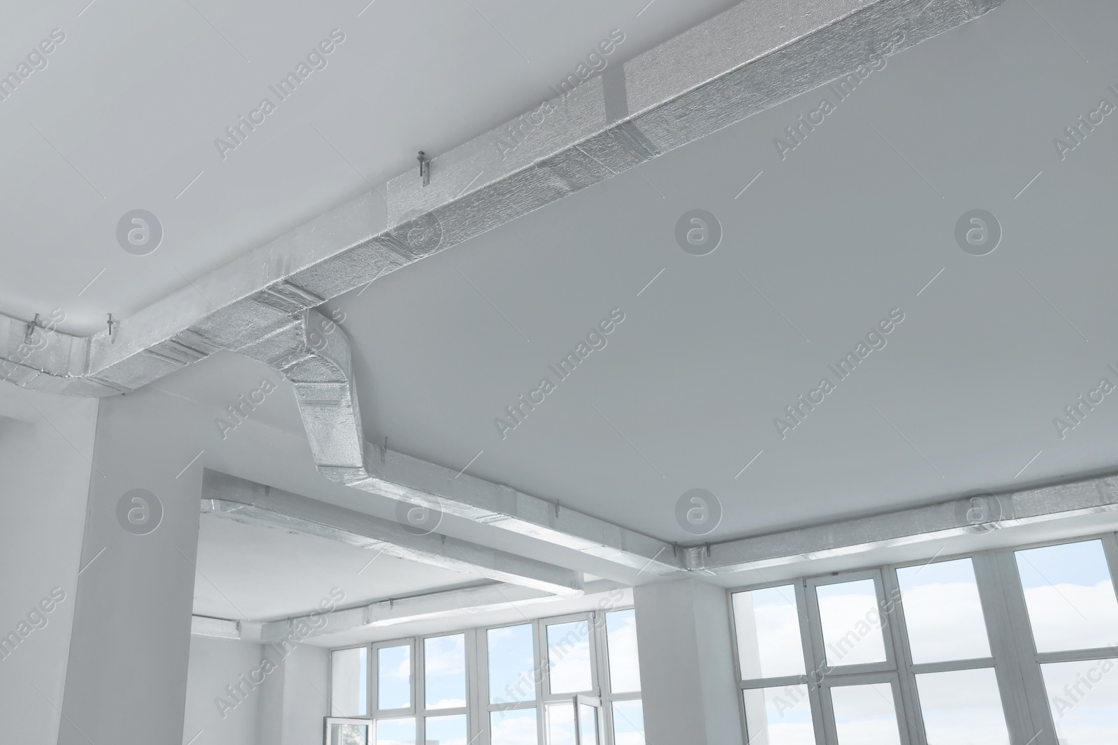 Photo of Ceiling with ventilation system indoors, low angle view