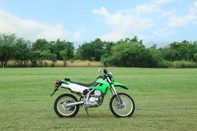 Stylish cross motorcycle on green grass outdoors