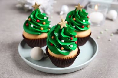 Christmas tree shaped cupcakes on light grey table